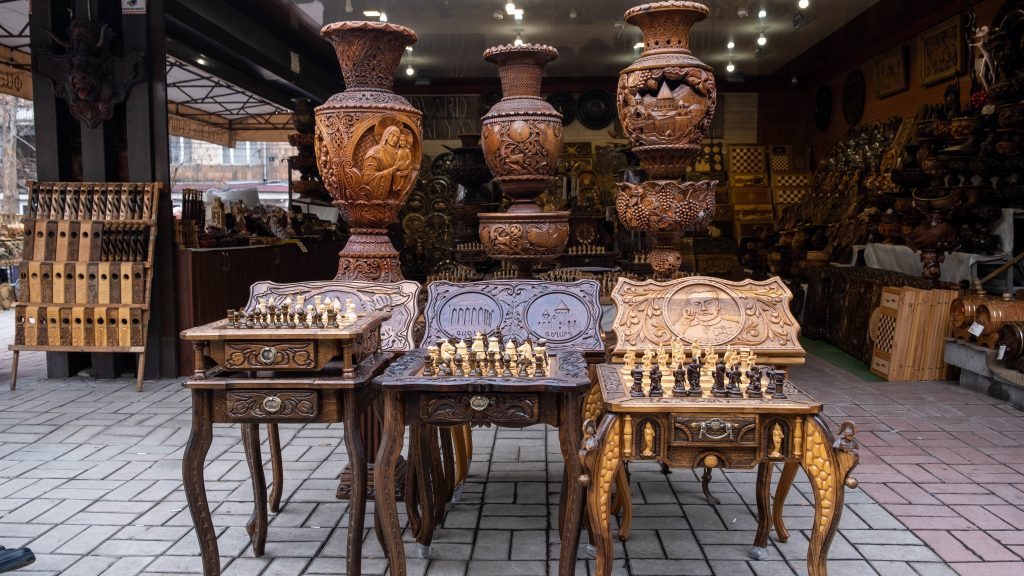 Handmade wooden chess sets and tables at Vernissage open-air market