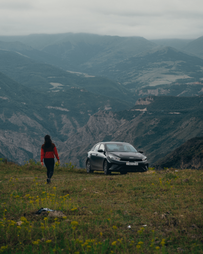 Rental car in Armenia parked near a scenic viewpoint during a road trip.